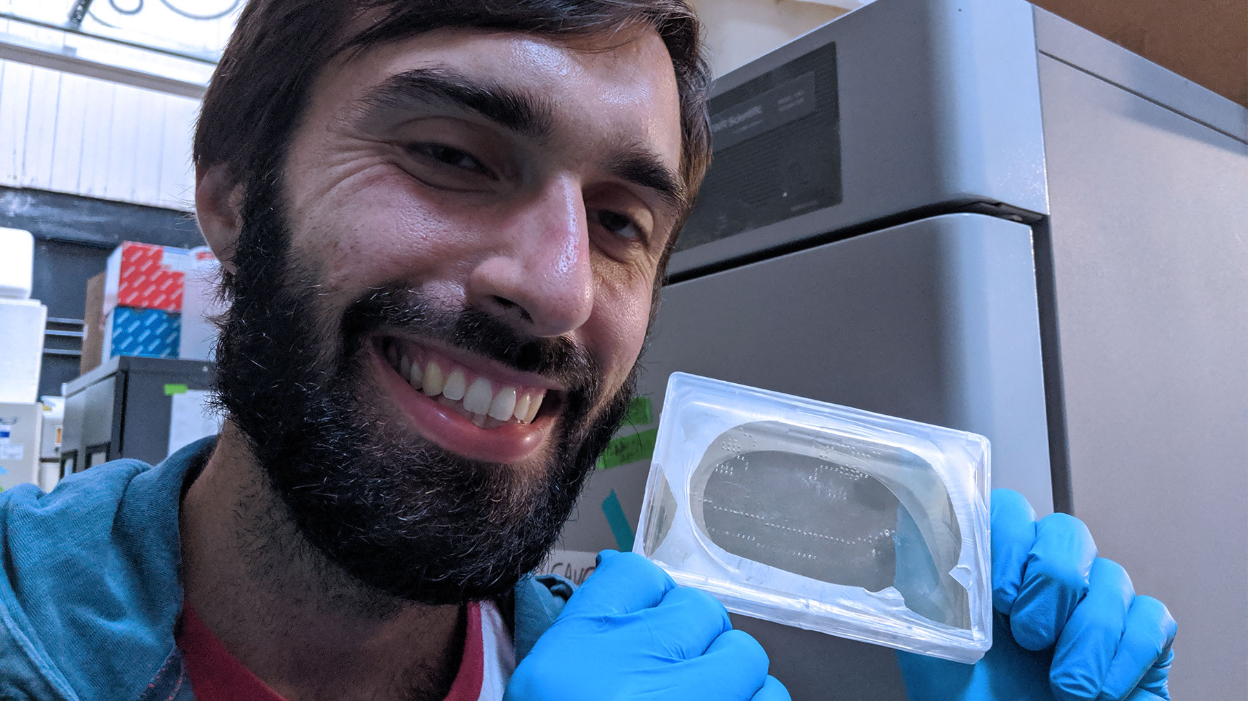 Tim holding one of our first tests, the smiley face agar plate, before putting it into the incubator.